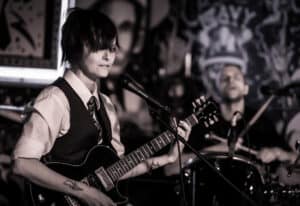 Buick Audra playing guitar with Friendship Commanders