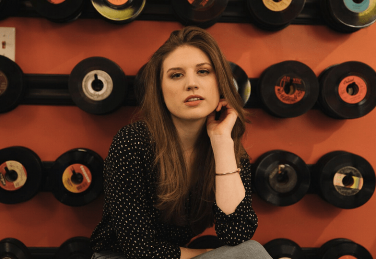 heather batchelor sitting in front of a wall of records