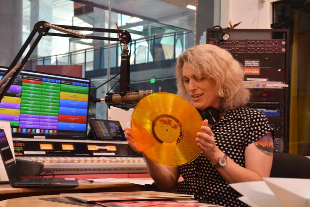 Dee Torrell holds a record in the WYXR studio.