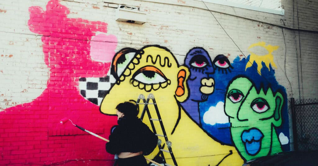 Shira Mae works on a mural that is almost complete.