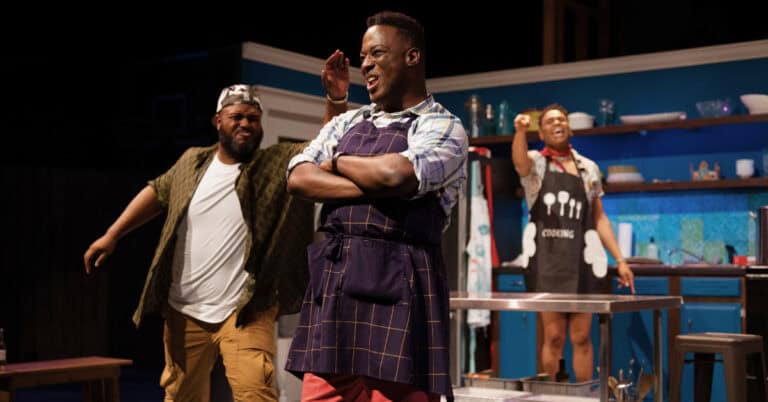 Three gay black men on stage in clothes like they might be about to cook in The Hot Wing King production