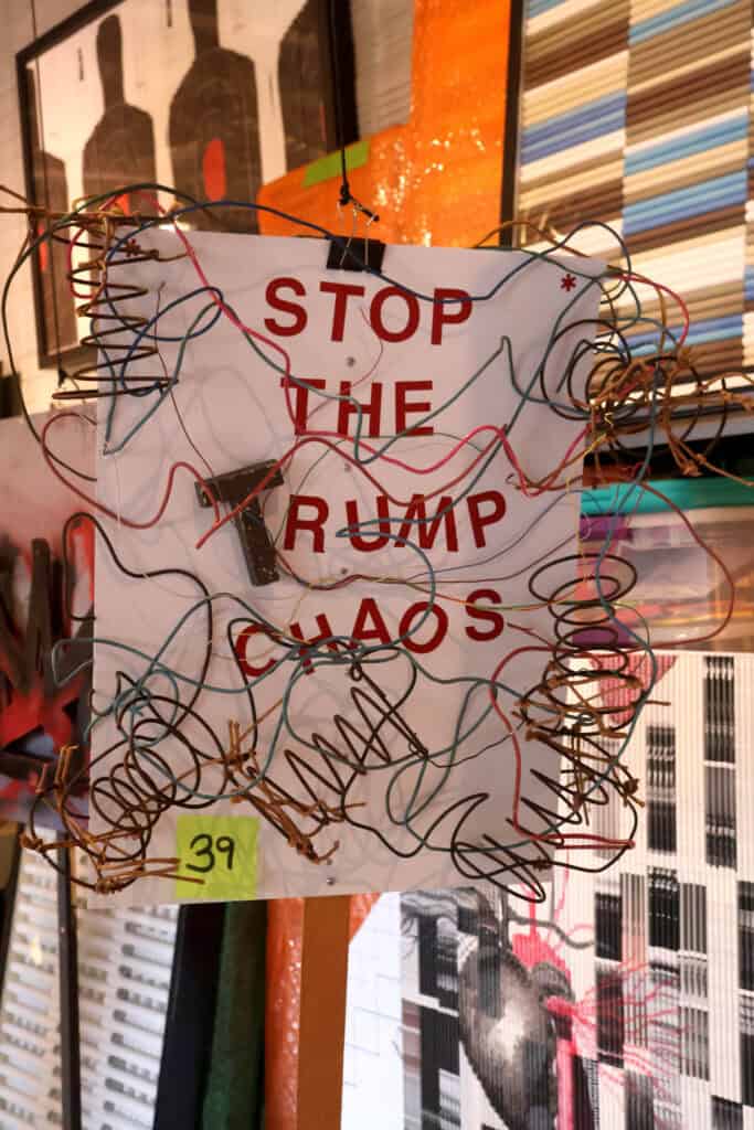 Sign with red letters reading 'STOP THE RUMP CHAOS' surrounded by colorful wires. — focuslgbt.com