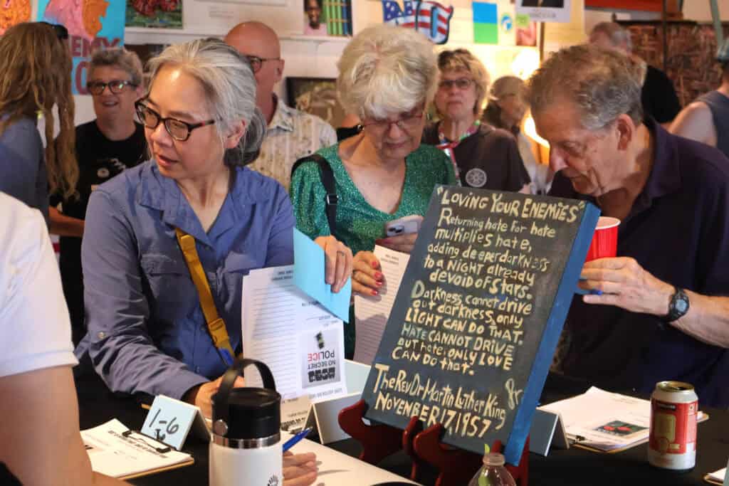 Older women read a handwritten poem at a book event in Memphis. — focuslgbt.com