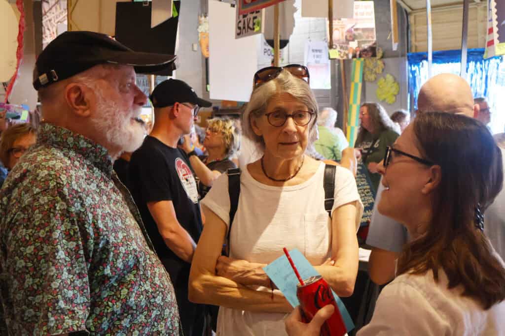Three people engaged in conversation at a Memphis Pride event. — focuslgbt.com