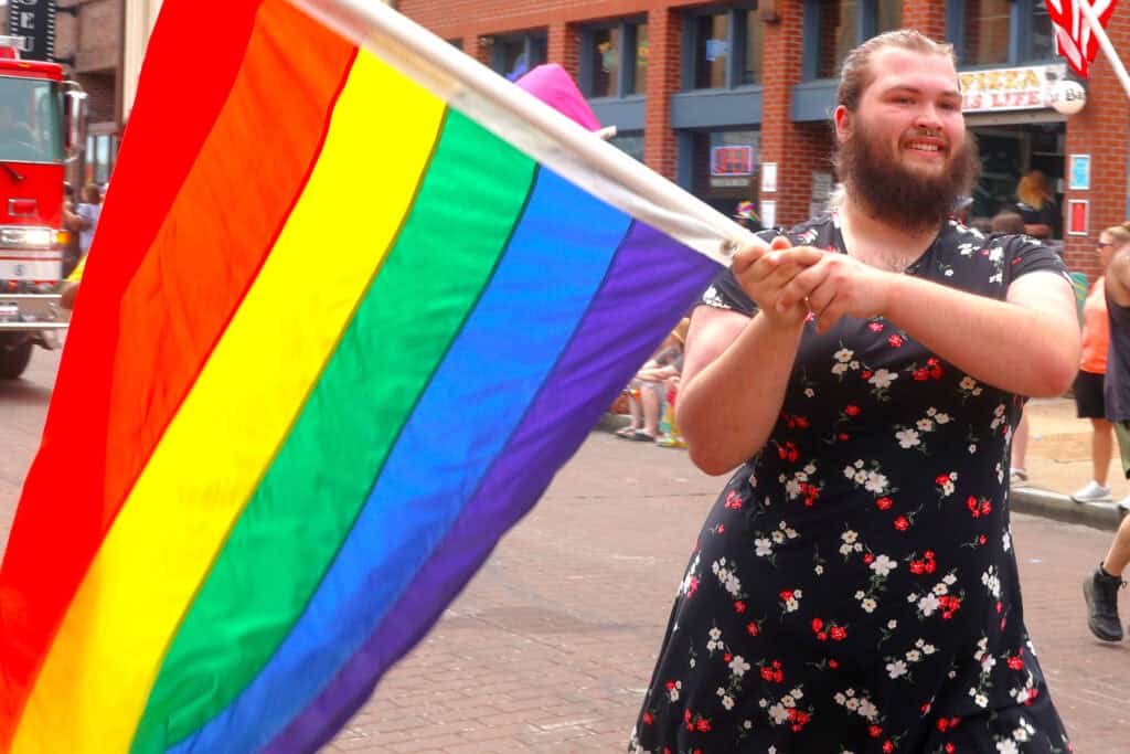 Person holding a rainbow pride flag at a pride parade in Memphis. — focuslgbt.com