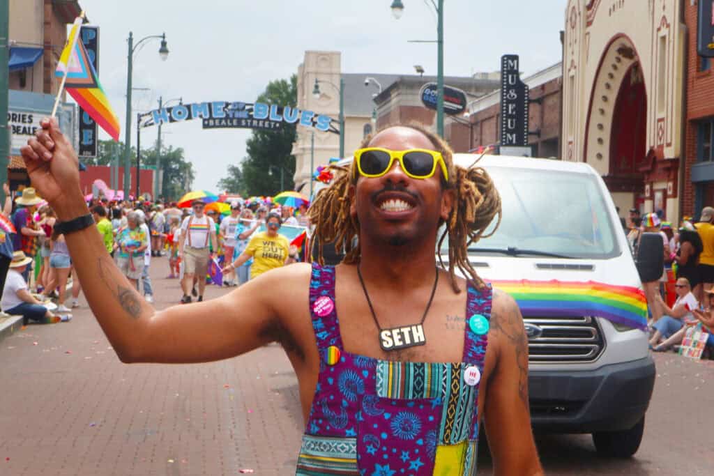 Person with yellow sunglasses and rainbow dress at Pride parade in Memphis. — focuslgbt.com