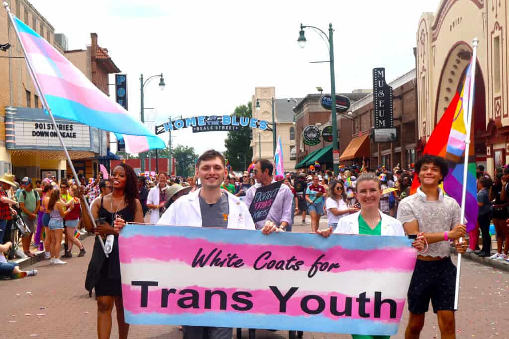 Participants hold a banner reading 'White Coats for Trans Youth' at a Pride parade in Memphis. — focuslgbt.com