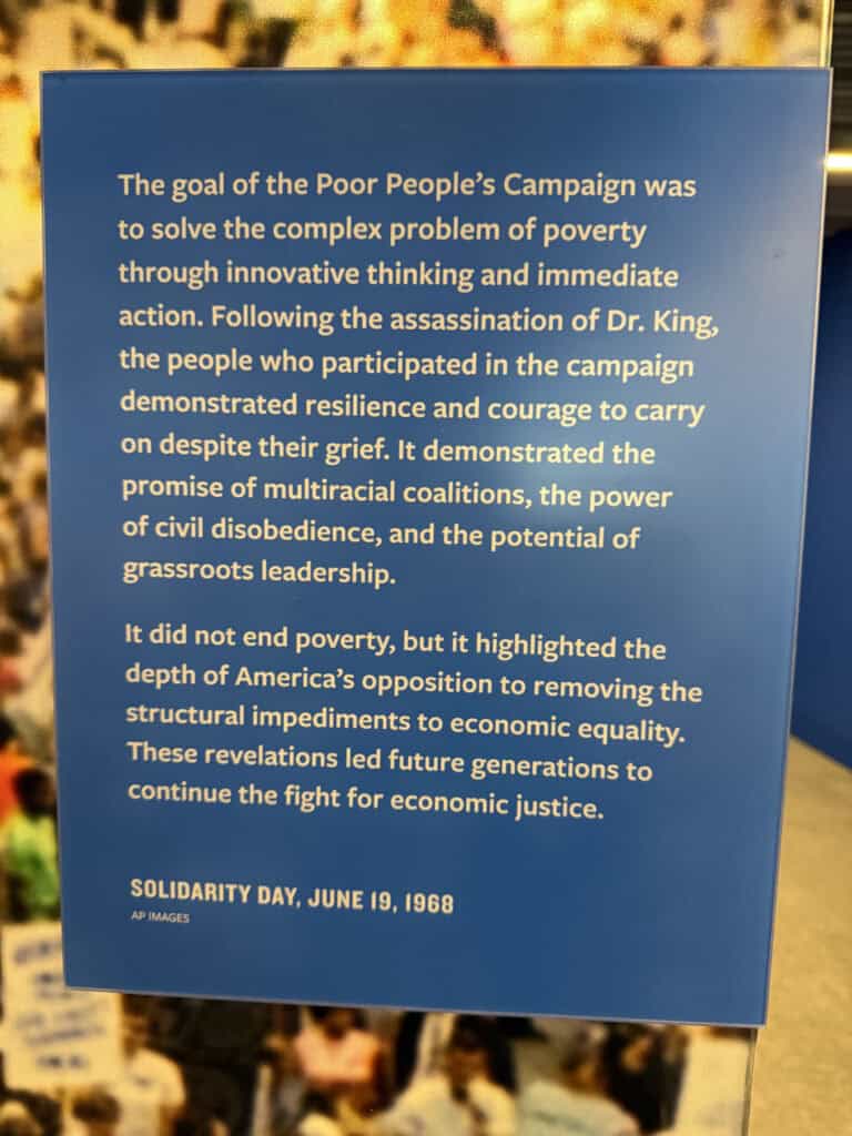Blue informational sign about the Poor People's Campaign and economic justice. — focuslgbt.com
