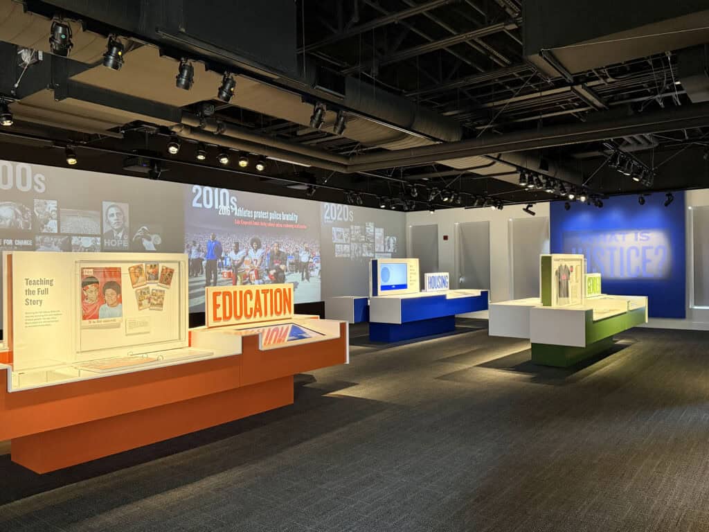 Exhibit displays books and digital screens about LGBTQ+ history and education. — focuslgbt.com