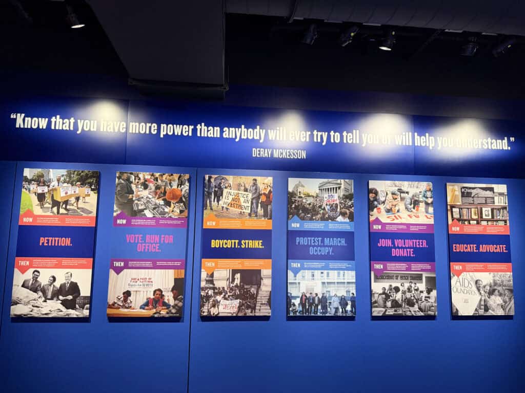 Exhibit with protest posters and a quote about power and understanding. — focuslgbt.com