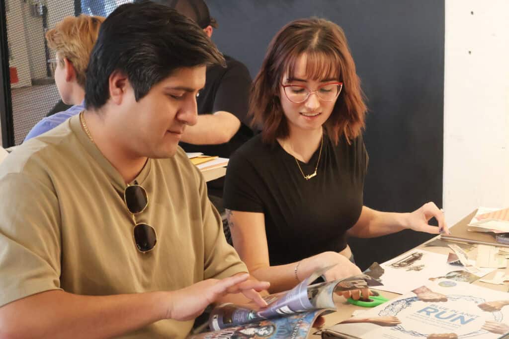 Two young adults look at comics at a table during a Memphis event. — focuslgbt.com