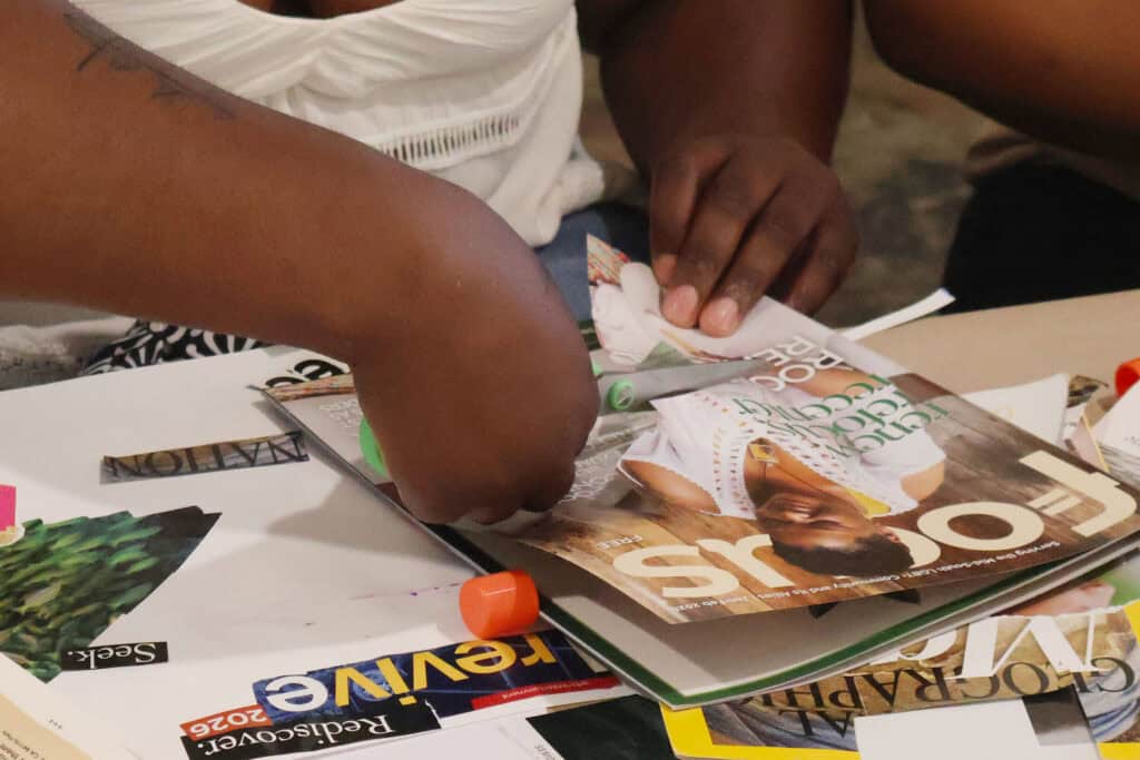 People's hands flipping through magazines at a table. — focuslgbt.com