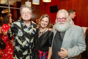 Three people smiling at a social event in Memphis, with a woman in the middle and two men on either. — focuslgbt.com