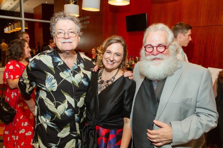 Three people smiling at a social event in Memphis, with a woman in the middle and two men on either. — focuslgbt.com