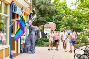 Group of people walking past rainbow flags outside a building in Memphis. — focuslgbt.com