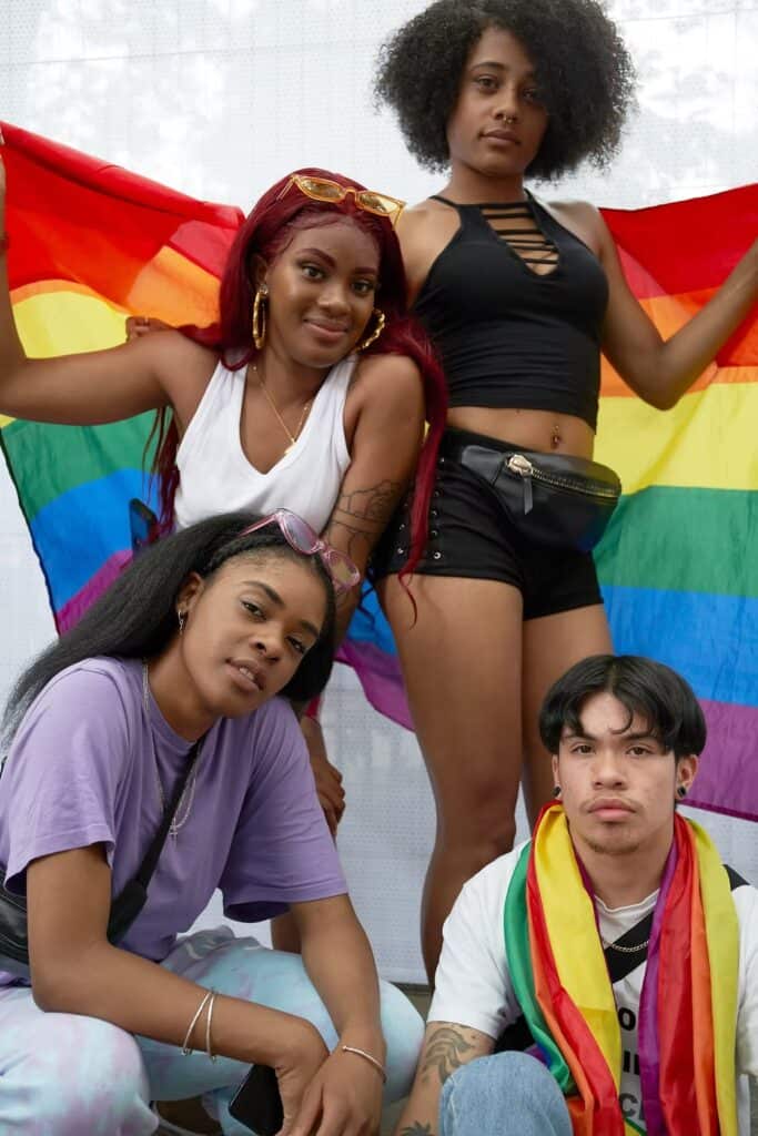 Four diverse individuals holding a rainbow pride flag at Memphis Pride event. — focuslgbt.com